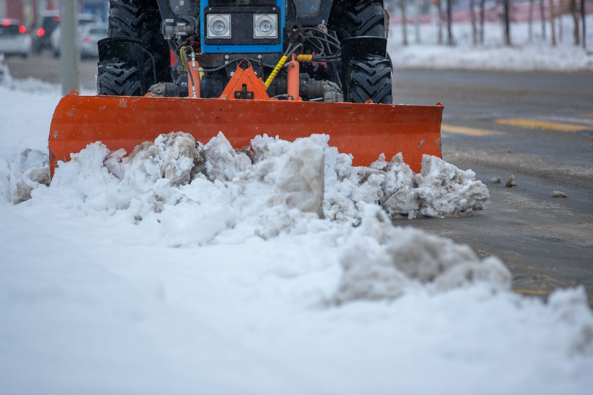 A snowplow clearing snow from a city street after a heavy winter snowstorm.